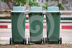 Row of green recycling bins in urban street