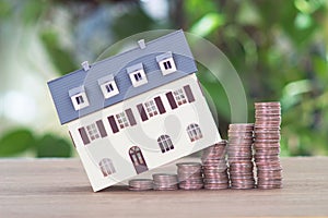 Row of growing dollar coins and a small house model