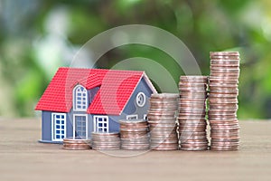 Row of growing dollar coins and a small house model