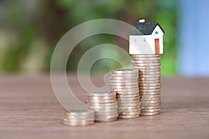 A row of growing euro coins and a miniature house mode