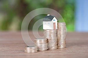 A row of growing euro coins and a miniature house mode