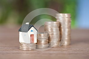 A row of growing euro coins and a miniature house mode