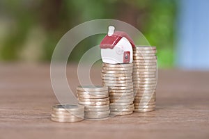 A row of growing euro coins and a miniature house mode