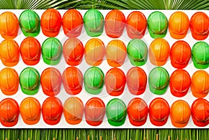 Row of grren and orange construction helmets