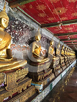A row of guilded Buddas in one of Bangkok temples photo