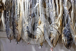 A row of hanging dried sea fish on a shop close up with selective focus