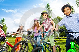 Row of happy children in bike colorful helmets