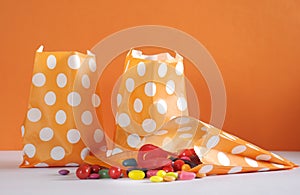 Row of Happy Halloween orange polka dot trick or treat paper bags