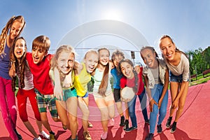 Row of happy teens standing on volleyball court