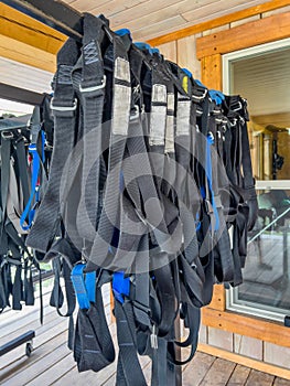 Row of harnesses ready for use at a high ropes and climbing course.