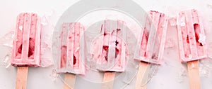 Row of healthy fresh strawberry frozen popsicles