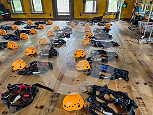 Row of helmets and harnesses ready for use at a high ropes and climbing course.