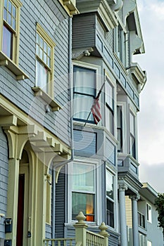 Row of house facades in the historic districts of San Francisco California in late afternoon shade with foggy background