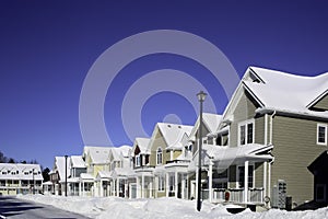Row of houses with snow on roofs and at front