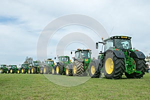 A row of John Deere Tractors at show