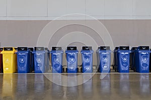 A row of large dark blue garbage containers