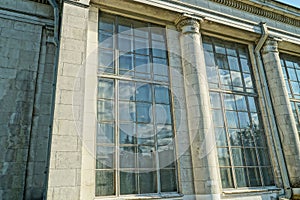 A row of large old windows on a gray stone wall