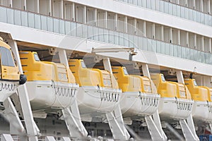 A row of lifeboats on a large cruise ship