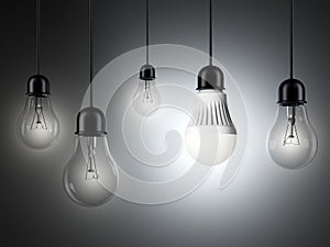 Row of light bulbs and glowing LED bulb