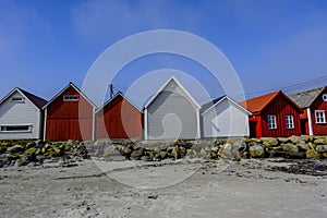 Row Or Line Of Traditional Wooden Beach Huts Facing A Sandy Beach