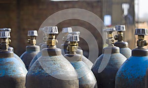 Row of liquefied oxygen industrial gas containers with valves. Close up of valves