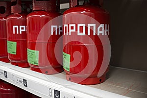 Row of liquefied propane industrial gas containers with russian inscription Propane . Construction shop