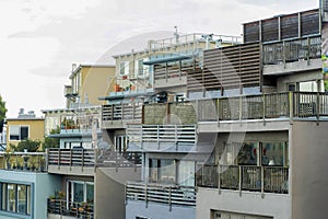 Row of load bearing apartment buildings with individual units and aged wooden balconies in late evening shade