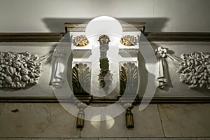 Row of luxurious wall lamp and stucco ornaments on the white glossy marble wall.