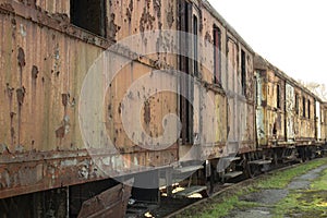 A row of many old rusty carriages fastened together