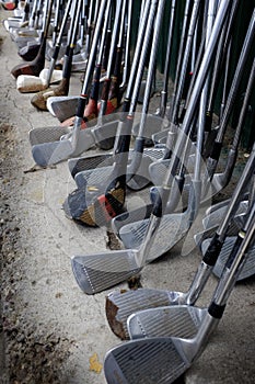 Row of Many Old Used Golf Clubs for Sport