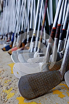 Row of Many Old Used Golf Clubs for Sport