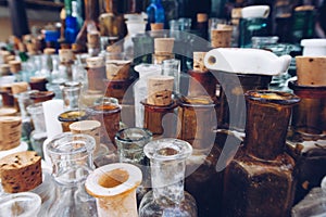 A row of many vintage medicine bottles. Close up selective focus photo of old antique pharmacy glass vials and flasks