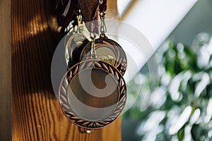 Row of medals hanging on a wall at home