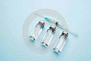 A row of medical vials. Glass bottles with a transparent medicine and a syringe.