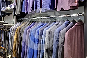 Row of men`s suits hanging in closet.