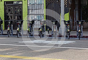 A row of metro bikes for rent on a sidewalk