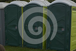 Row of mobile green bio toilets outside