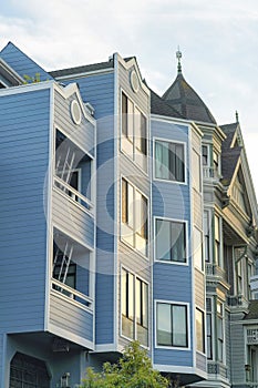 Row of modern apartment units in wooden or timber building with decorative windows and roofs on the homes with late
