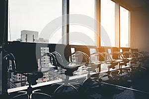 Row of modern black chair in empty office space with large window view cityscape, vintage picture style process, business meeting