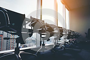 Row of modern black chair in empty office space with large window view cityscape, vintage picture style process, business meeting