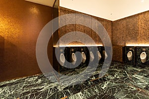Row of modern urinals men public toilet room in public toilet, restroom in restaurant or hotel or shopping mall, interior