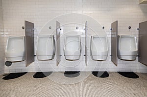 A Row of  modern water conserving white porciline urinals in public restroom