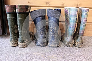 Row of muddy dirty rubber boots after working on construction and building