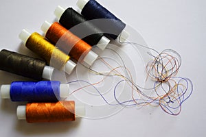 Row of multicolored spools of sewing threads on a white table. Workplace of seamstress. Sewing background with copy