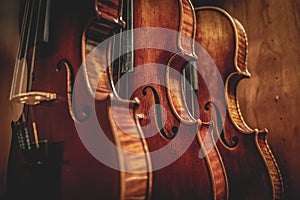 Row of multiple violins hanging on the wall, musician workshop