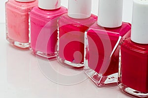 Row of nail polish bottles in different pink colors..