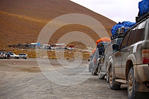 Row of off road vehicles stopped for rest. Adventure in Bolivia highlands in the Andes.