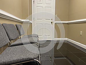 A row of office lobby waiting chairs and white door