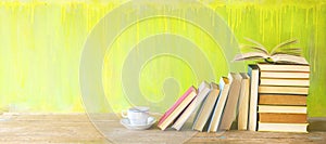 Row of old books and a cup of coffee on a rustic book shelf.