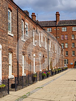 row of old brick built terraced house in the north of England Manchester, with black iron railings outside